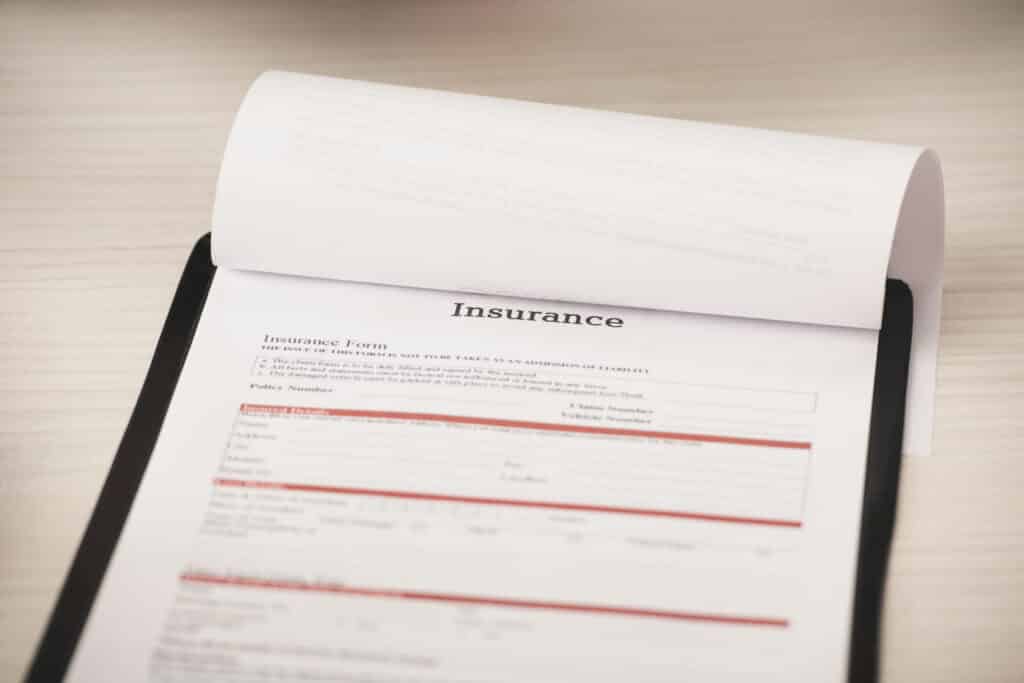 selective focus of clipboard with insurance lettering of desk